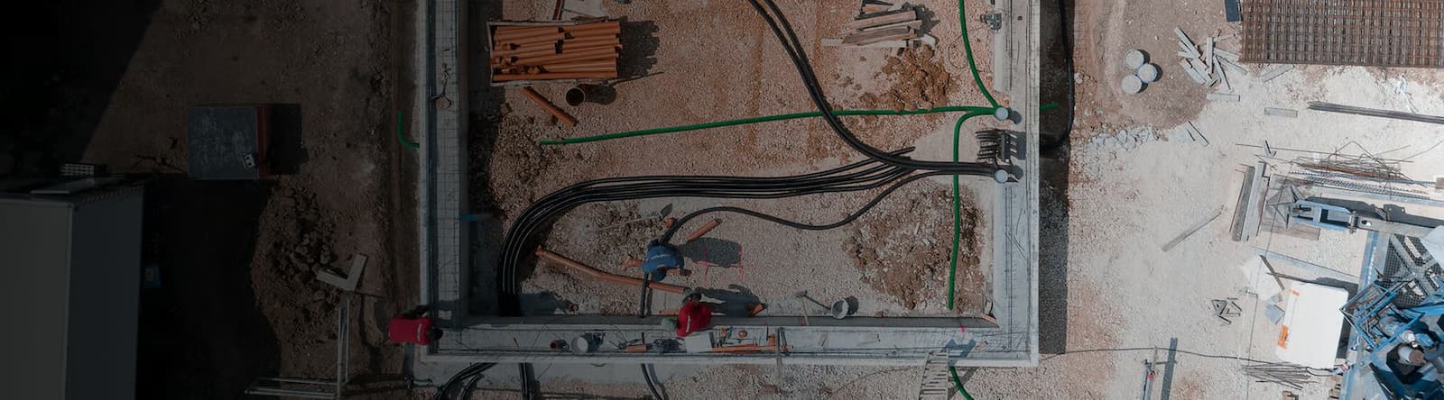 Vogelperspektive auf eine Baustelle mit verlegten Leerrohren und Leitungen für eine Mehrspartenhauseinführung